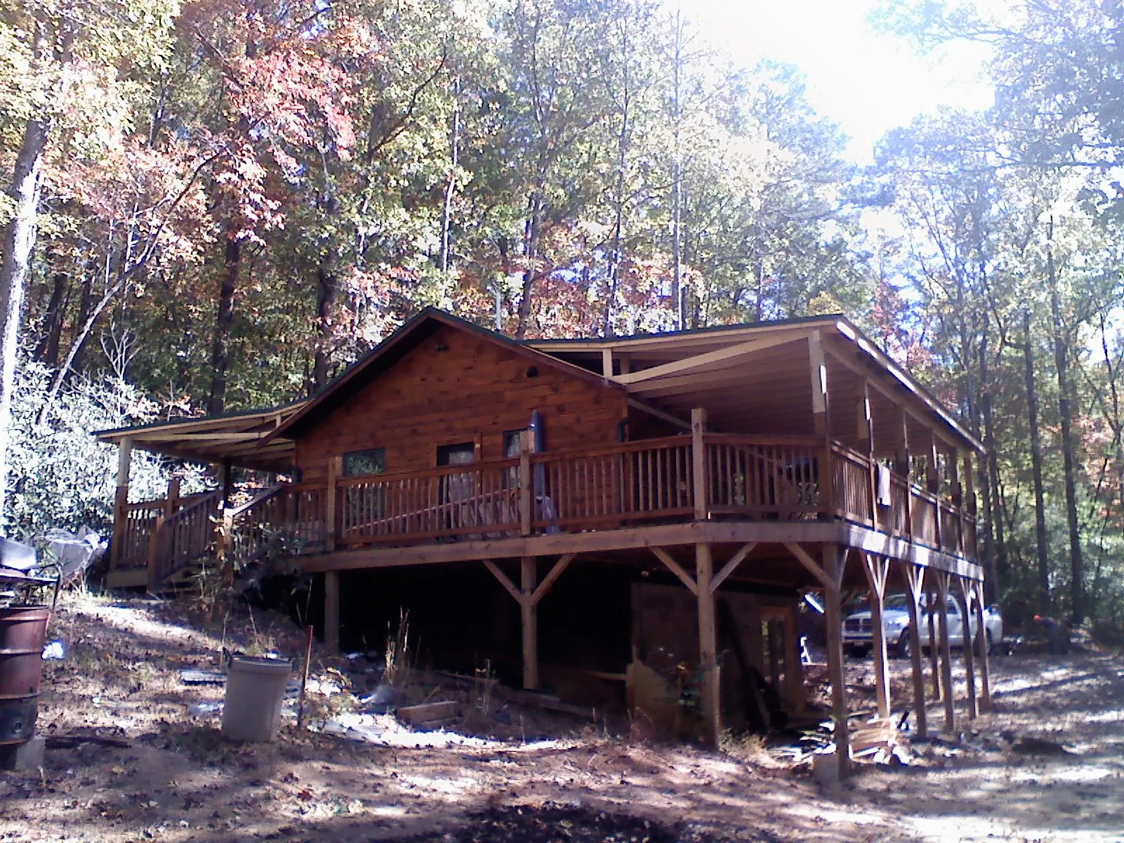 Log cabin with a wraparound porch and metal roof in the fall in Montrose